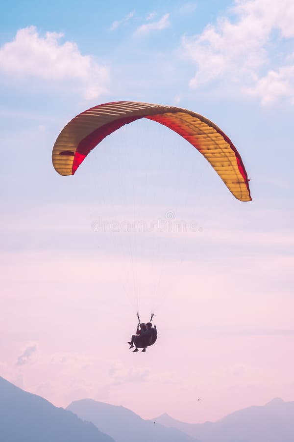 Alianti in tandem che volano nel tramonto sopra Interlaken in Svizzera Siluette delle alpi svizzere, cielo rosa di tramonto avven fotografia stock libera da diritti Alianti in tandem che volano nel tramonto sopra Interlaken in Svizzera Siluette delle alpi svizzere, cielo rosa di tramonto avven fotografia stock libera da diritti
