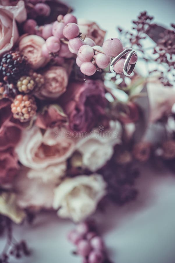 Alianças de casamento em um ramalhete de flores coloridas fotos de stock Alianças de casamento em um ramalhete de flores coloridas fotos de stock