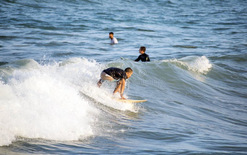 Alicante, España, 25 de agosto de 2019: Surfer recorre una ola en el mar Mediterráneo a orillas del mar imagen de archivo Alicante, España, 25 de agosto de 2019: Surfer recorre una ola en el mar Mediterráneo a orillas del mar imagen de archivo