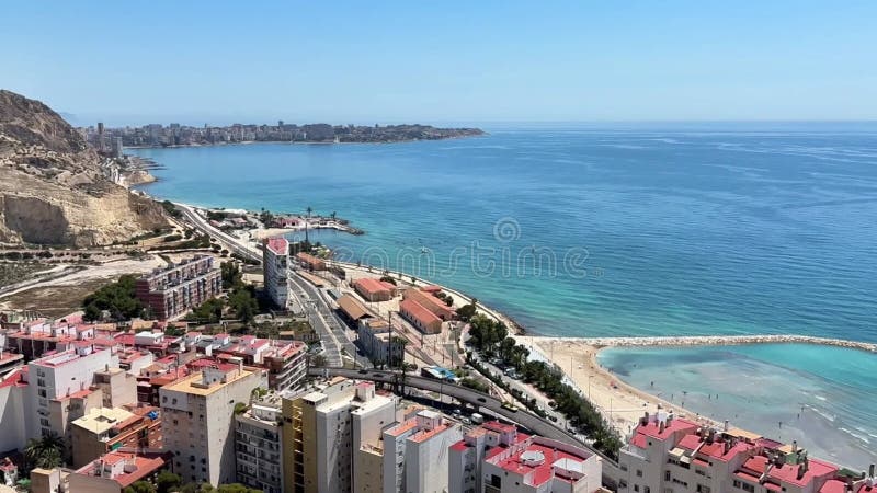 Alicante España 30 de mayo de 2025 : Vista aérea de la ciudad costera con vibrantes edificios de playa de arena y aguas cristalina almacen de metraje de vídeo