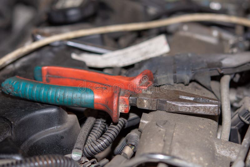 Alicates combinados en el motor diesel viejo Concepto de las reparaciones del mecánico de coche con el motor de coche viejo foto de archivo libre de regalías Alicates combinados en el motor diesel viejo Concepto de las reparaciones del mecánico de coche con el motor de coche viejo foto de archivo libre de regalías