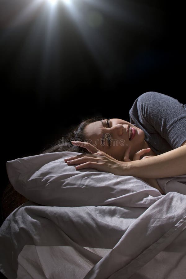 Creepy glowing orb hovering over a woman sleeping in bed. Creepy glowing orb hovering over a woman sleeping in bed