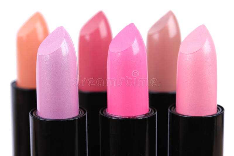 Align lipsticks different colours, closeup on white