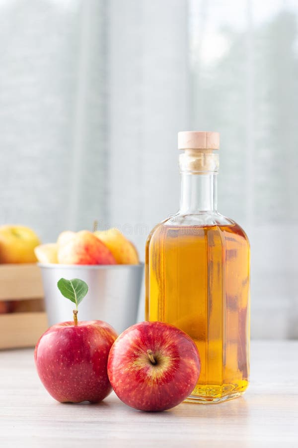 Aliment biologique sain Vinaigre ou jus de cidre d'Apple dans la bouteille en verre et les pommes rouges fraîches photographie stock Aliment biologique sain Vinaigre ou jus de cidre d'Apple dans la bouteille en verre et les pommes rouges fraîches photographie stock