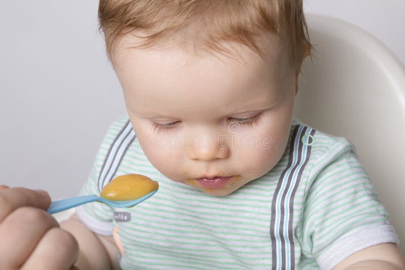 Alimentation d'un petit enfant image stock Alimentation d'un petit enfant image stock