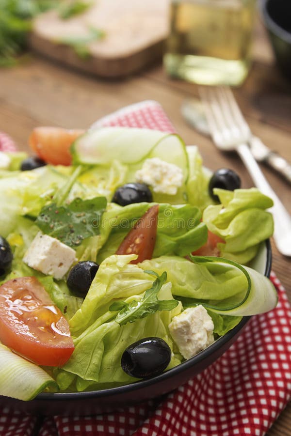 Alimenti sani Insalata con formaggio feta, pomodori, lattuga verde e olive nere Alimentazione sana Tavola di legno fotografia stock Alimenti sani Insalata con formaggio feta, pomodori, lattuga verde e olive nere Alimentazione sana Tavola di legno fotografia stock