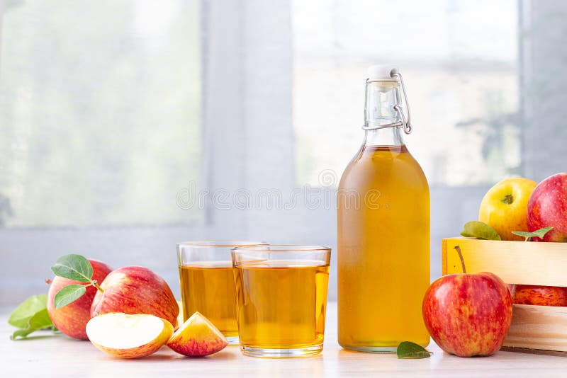 Alimento biologico sano Aceto o succo di sidro di Apple in bottiglia di vetro ed in mele rosse fresche