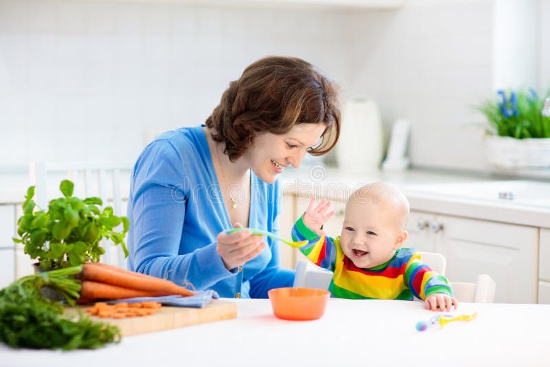 Alimento contínuo de alimentação do bebê da mãe primeiro foto de stock Alimento contínuo de alimentação do bebê da mãe primeiro foto de stock