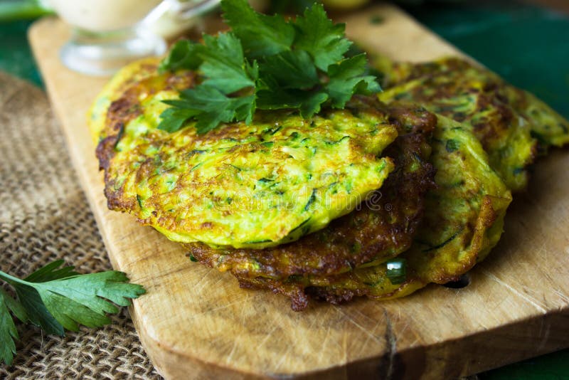 Alimento del ristorante - pancake deliziosi con lo zucchini di verdure con panna acida, stile rustico fotografie stock libere da diritti Alimento del ristorante - pancake deliziosi con lo zucchini di verdure con panna acida, stile rustico fotografie stock libere da diritti