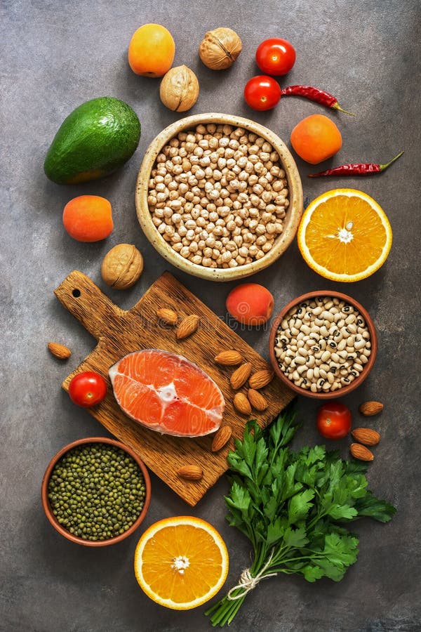 Alimento equilibrato sano, salmone, legumi, frutti, verdure, dadi, fondo rustico scuro Il concetto di cibo sano Disposizione pian fotografie stock Alimento equilibrato sano, salmone, legumi, frutti, verdure, dadi, fondo rustico scuro Il concetto di cibo sano Disposizione pian fotografie stock