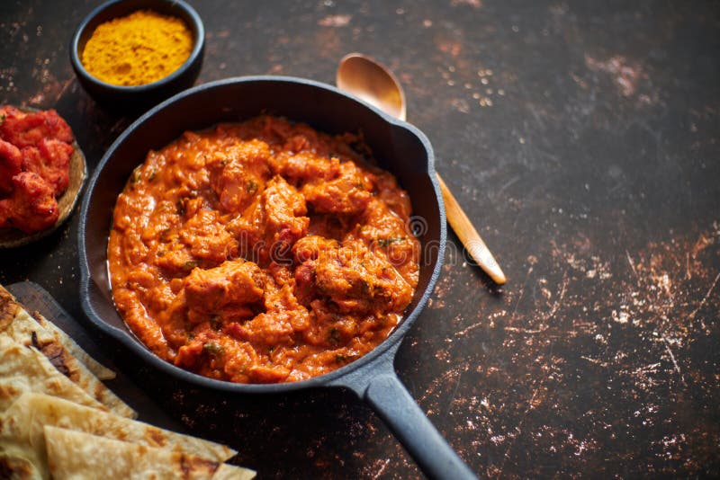Alimento picante da carne do caril do masala indiano tradicional do tikka da galinha na bandeja do ferro fundido foto de stock Alimento picante da carne do caril do masala indiano tradicional do tikka da galinha na bandeja do ferro fundido foto de stock