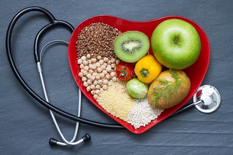 Alimento sano sul piatto rosso del cuore fotografia stock Alimento sano sul piatto rosso del cuore fotografia stock