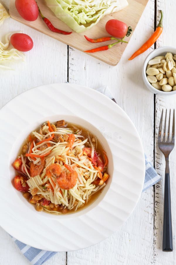 Alimento tailandese famoso dell'insalata della papaia sulla tavola di legno bianca fotografia stock Alimento tailandese famoso dell'insalata della papaia sulla tavola di legno bianca fotografia stock
