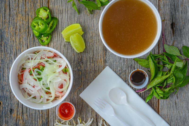 Pho Fast Food To Go on Wood Background with Peppers and Basil. Pho Fast Food To Go on Wood Background with Peppers and Basil