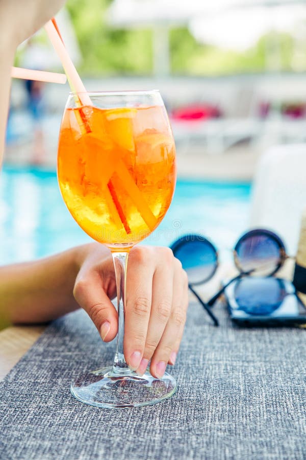 Alkoholischer Cocktail, Passionsfrucht, Orange, Spritze Drink Aperol, in einem Restaurant in der Hand eines Mädchens in einem teu stockfotografie Alkoholischer Cocktail, Passionsfrucht, Orange, Spritze Drink Aperol, in einem Restaurant in der Hand eines Mädchens in einem teu stockfotografie