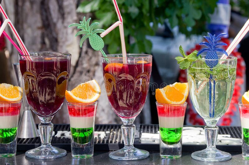 Alkoholiserade starksprit och mjuka uppfriskningdrinkar vid exponeringsglaset på stången utomhus royaltyfri bild Alkoholiserade starksprit och mjuka uppfriskningdrinkar vid exponeringsglaset på stången utomhus royaltyfri bild