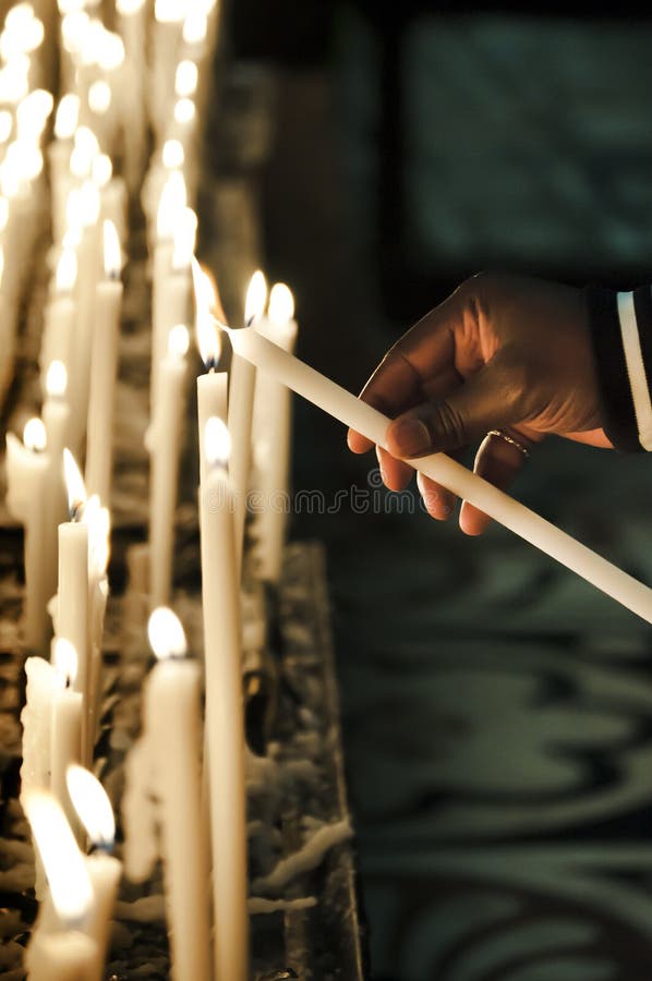 Encendiendo votivo vela en catedral de estimado.