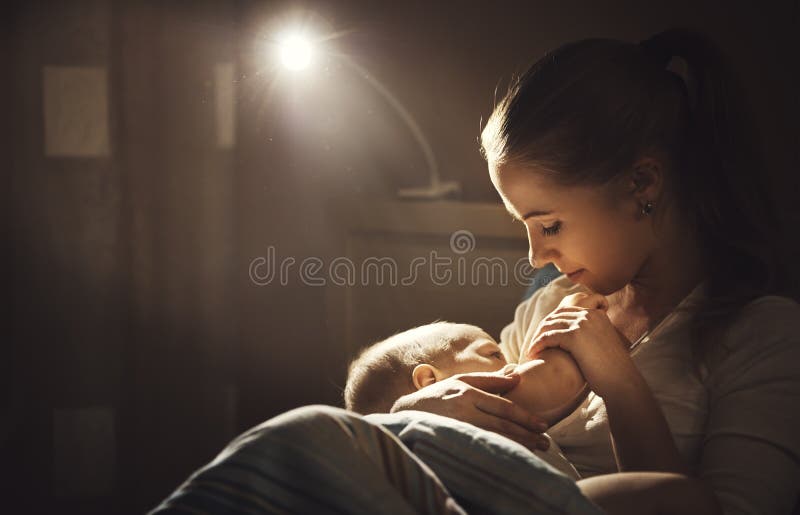 Allattamento al seno notte scura d'alimentazione del seno del bambino della madre a letto