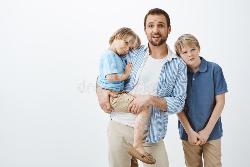 Alleenstaande ouder die voor zonen zorgen Papa die leuk kind met vitiligo houden terwijl het staren zenuwachtig bij camera die, w stock foto's Alleenstaande ouder die voor zonen zorgen Papa die leuk kind met vitiligo houden terwijl het staren zenuwachtig bij camera die, w stock foto's