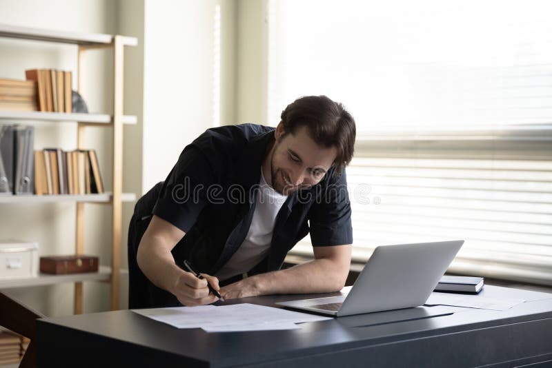 Allegro e soddisfatto uomo d'affari che firma documenti di revisione del contratto immagine stock