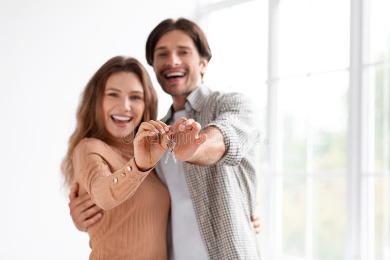 Allegro soddisfatto millenario caucasiano maschio e femmina che festeggiano comprando le chiavi del proprio appartamento immagine stock