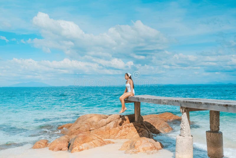 Allein stehende Frau am Meer, die den Blick auf den blauen Ozean am Strand genießt. Reisefotos und Ferien in Kho mun Nork Thailand stockfotografie