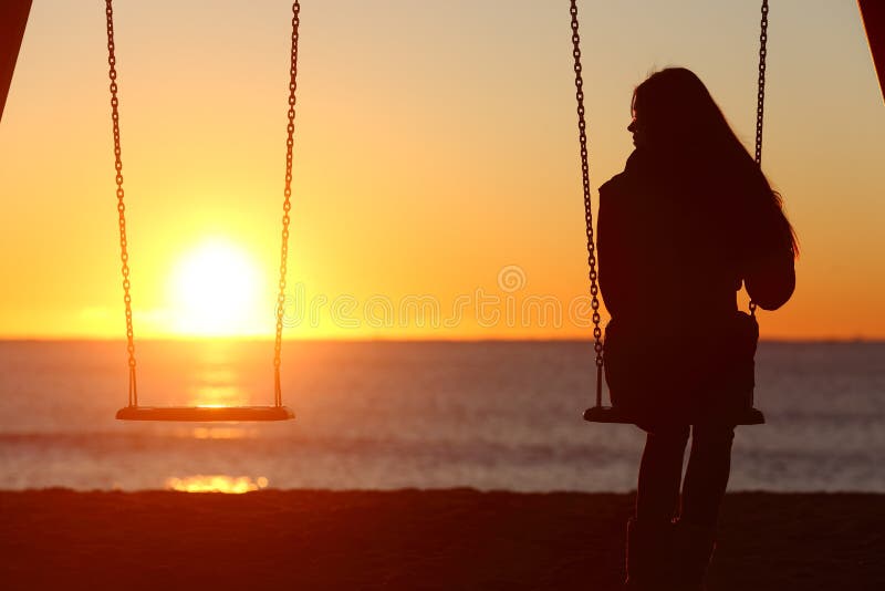 Alleinschwingen der allein stehenden Frau auf dem Strand