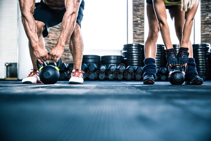 Allenamento muscolare della donna di misura e dell'uomo con la palla del bollitore immagine stock Allenamento muscolare della donna di misura e dell'uomo con la palla del bollitore immagine stock