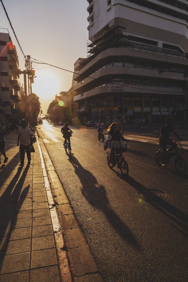 Tel Aviv-Yafo, Israel - June 6, 2018: Sunset scene with bike riders at Allenby Road in Tel Aviv, Israel. Bikes are the most popular transportation in Tel Aviv. Tel Aviv-Yafo, Israel - June 6, 2018: Sunset scene with bike riders at Allenby Road in Tel Aviv, Israel. Bikes are the most popular transportation in Tel Aviv.