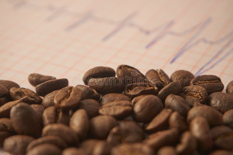 Allenti i chicchi di caffè arrostiti su un tracciato di ECG fotografie stock libere da diritti Allenti i chicchi di caffè arrostiti su un tracciato di ECG fotografie stock libere da diritti