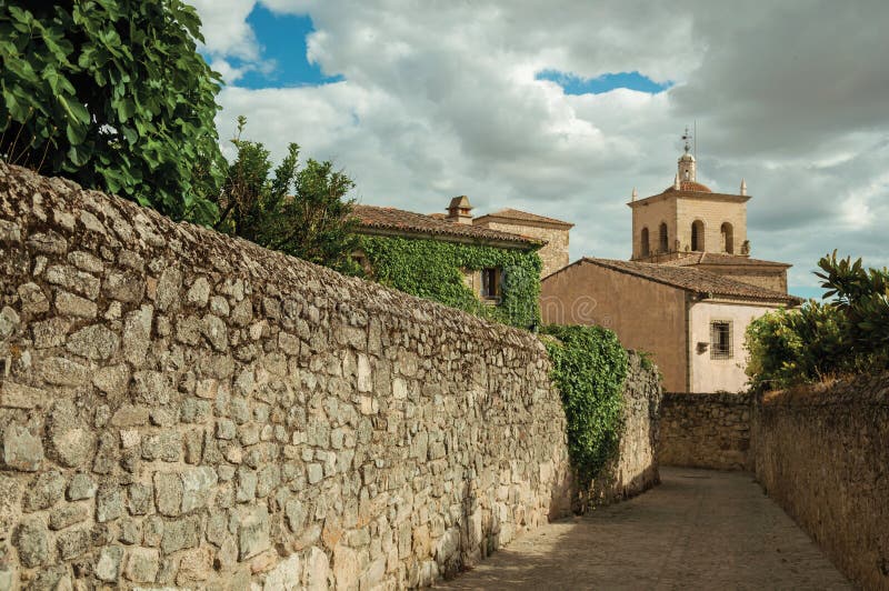 Alley with stone walls going towards Church and steeple at Trujillo stock photos Alley with stone walls going towards Church and steeple at Trujillo stock photos