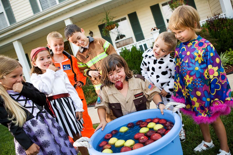 Group of neighborhood children on Halloween, having fun in costume trick-or-treating and playing games. Group of neighborhood children on Halloween, having fun in costume trick-or-treating and playing games.