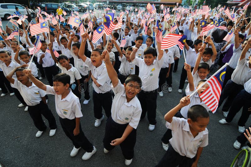 Allievi che salutano la bandiera della Malesia immagine stock libera da diritti