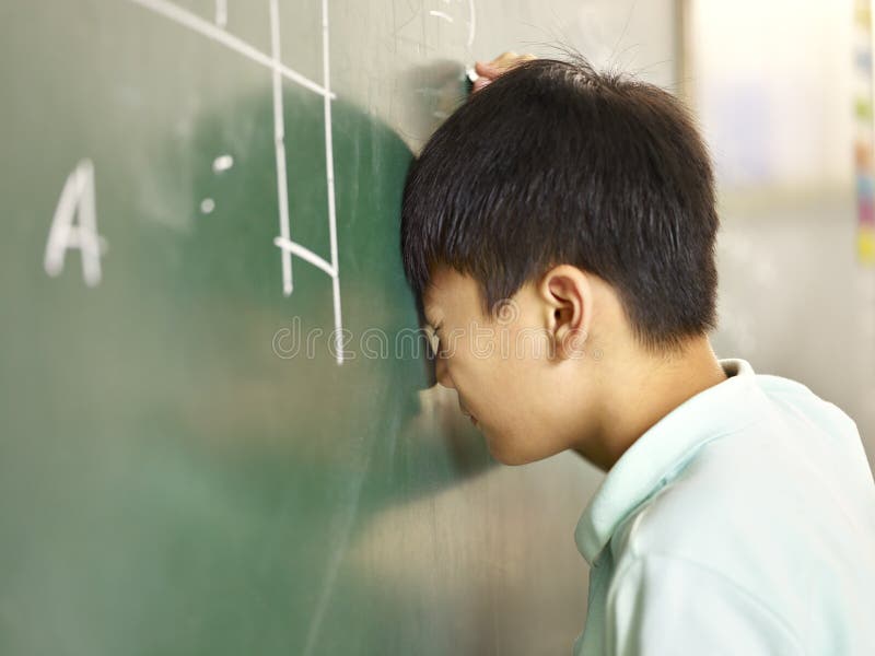 Painful asian elementary schoolboy banging his head on blackboard while solving geometry problem. Painful asian elementary schoolboy banging his head on blackboard while solving geometry problem.