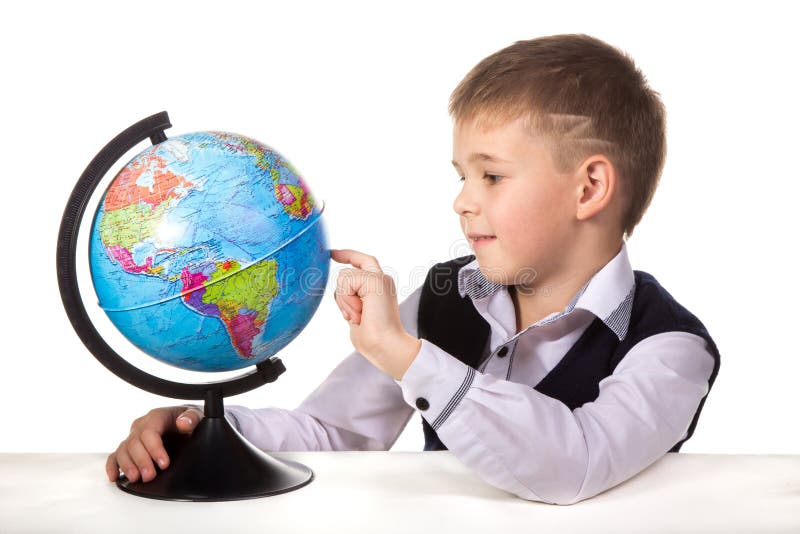 Allievo con un globo Allievo soddisfatto allegro che si siede allo scrittorio sui precedenti bianchi immagini stock libere da diritti