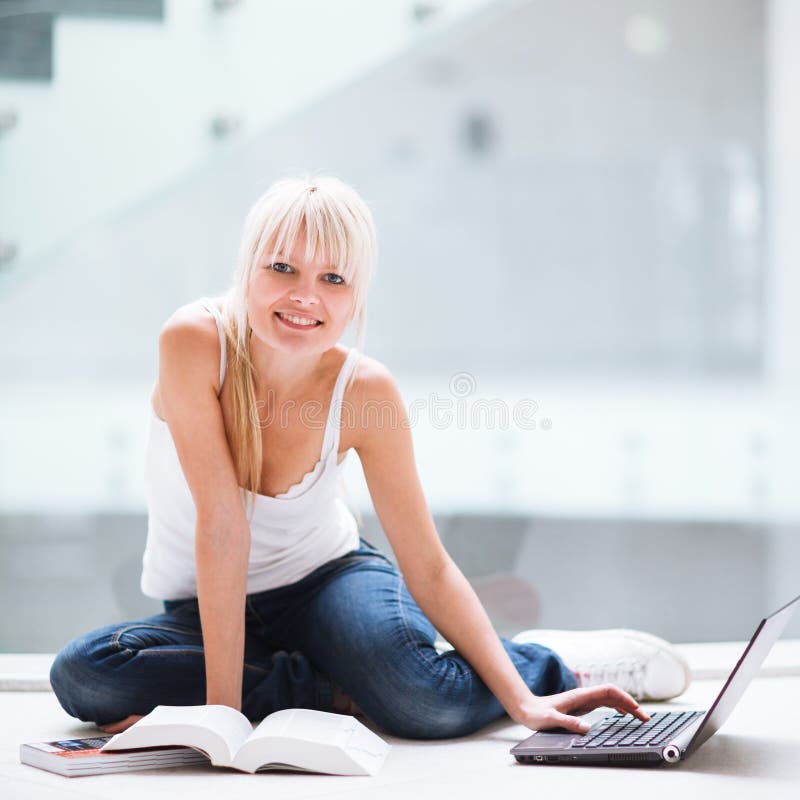Allievo femminile grazioso con il computer portatile ed i libri fotografia stock libera da diritti