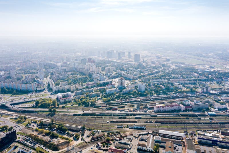 Aerial panoramic image of city industrial district. Buildings, plants, factories on blue foggy sky background. Aerial panoramic image of city industrial district. Buildings, plants, factories on blue foggy sky background