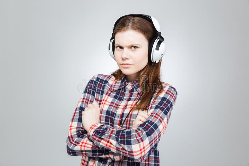 Allvarlig nätt tonårs- flicka som lyssnar till musik i hörlurar royaltyfria foton Allvarlig nätt tonårs- flicka som lyssnar till musik i hörlurar royaltyfria foton