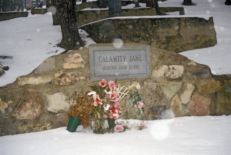 Allvarlig plats av Calamity Jane, ökänd fredlös i den monteringsMoriah kyrkogården, Deadwood, SD i vintersnö royaltyfri fotografi Allvarlig plats av Calamity Jane, ökänd fredlös i den monteringsMoriah kyrkogården, Deadwood, SD i vintersnö royaltyfri fotografi