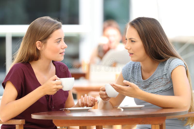 Two serious friends talking sitting in a restaurant. Two serious friends talking sitting in a restaurant