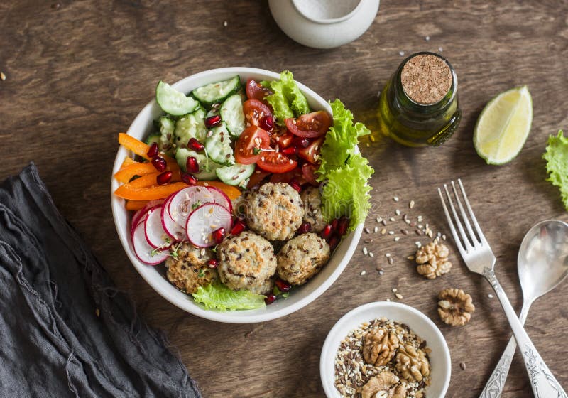 Almôndegas cozidas do quinoa e salada vegetal em uma tabela de madeira, vista superior Bacia da Buda Saudável, dieta, conceito do