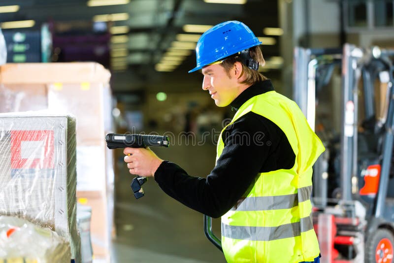 Warehouseman in protective vest using a scanner, standing beside packages and boxes at warehouse of freight forwarding company- a forklift is in Background. Warehouseman in protective vest using a scanner, standing beside packages and boxes at warehouse of freight forwarding company- a forklift is in Background