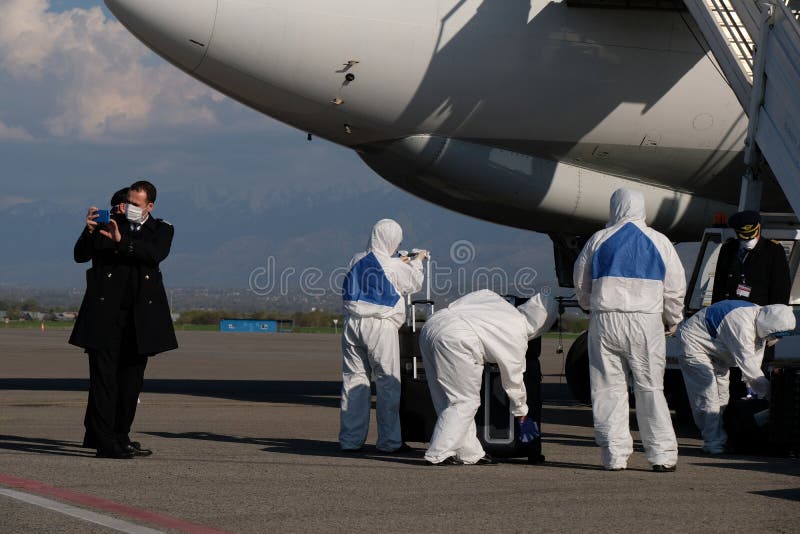 Almaty kazajstan 04182020 : personal del aeropuerto y médicos descargan carga humanitaria carga turca