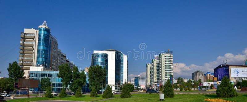 Almaty miasta budynki na letnim dniu z kwiatami i fontain w przodzie obrazy stock Almaty miasta budynki na letnim dniu z kwiatami i fontain w przodzie obrazy stock