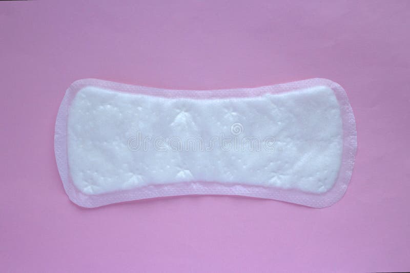 A almofada sanitária da mulher no fundo cor-de-rosa, conceito feminino da higiene fotografia de stock A almofada sanitária da mulher no fundo cor-de-rosa, conceito feminino da higiene fotografia de stock