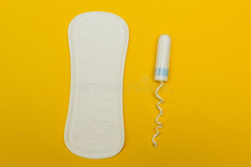 Almofadas sanitárias e tampão em um fundo amarelo imagem de stock Almofadas sanitárias e tampão em um fundo amarelo imagem de stock