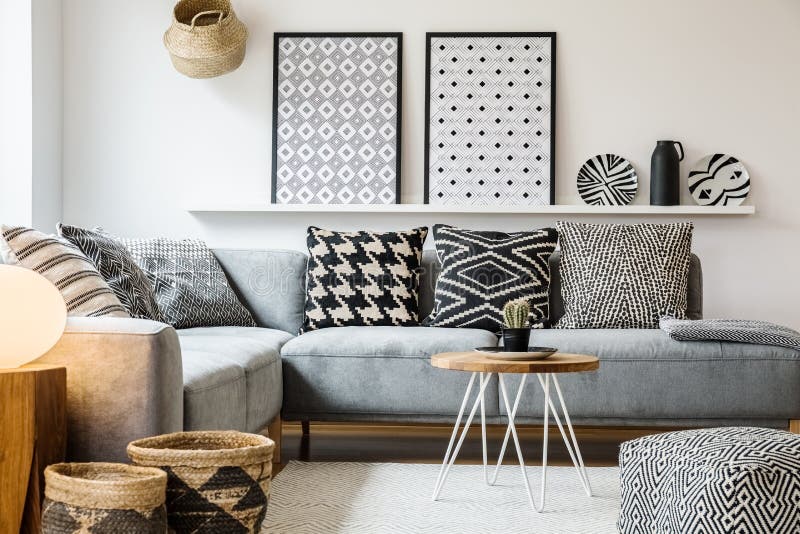 Almohadas modeladas en el sofá de la esquina gris en el apartamento foto de archivo libre de regalías Almohadas modeladas en el sofá de la esquina gris en el apartamento foto de archivo libre de regalías