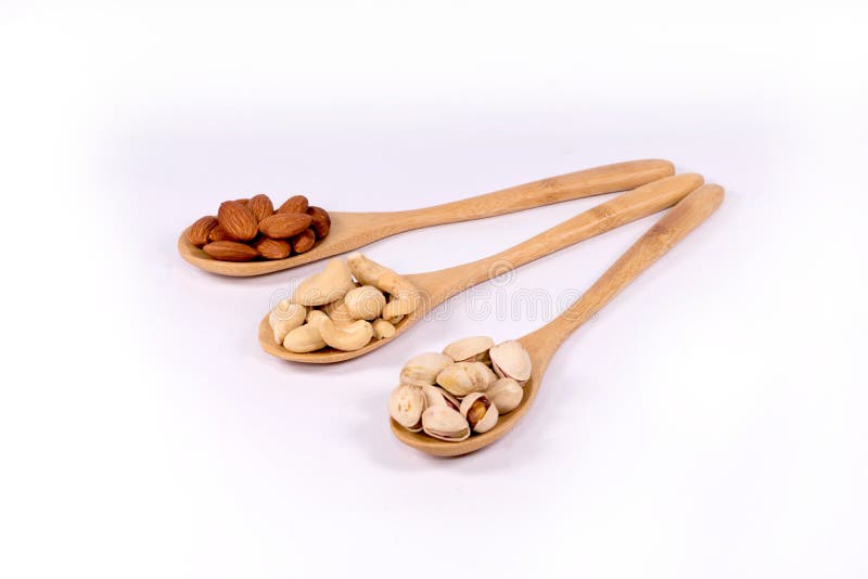 Almond nuts,cashew and pistachio in wooden spoon on white backg stock images Almond nuts,cashew and pistachio in wooden spoon on white backg stock images
