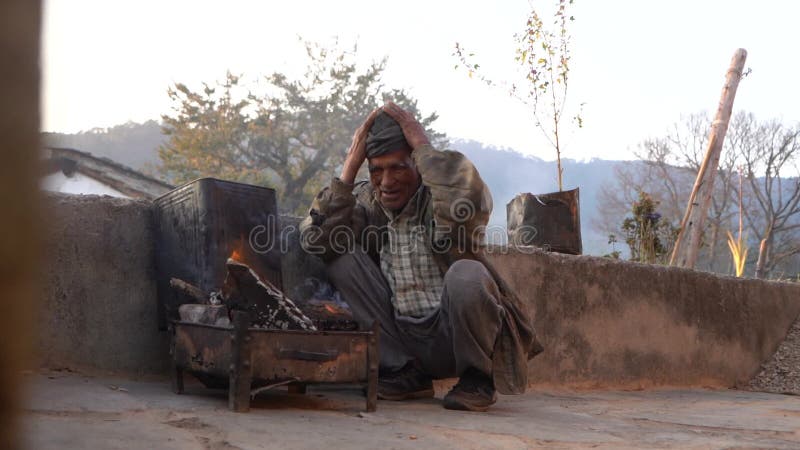 Almora uttarakhand 4 gennaio 2022 un anziano seduto accanto al fuoco cerca di riscaldarsi dal fuoco. un anziano di villaggio