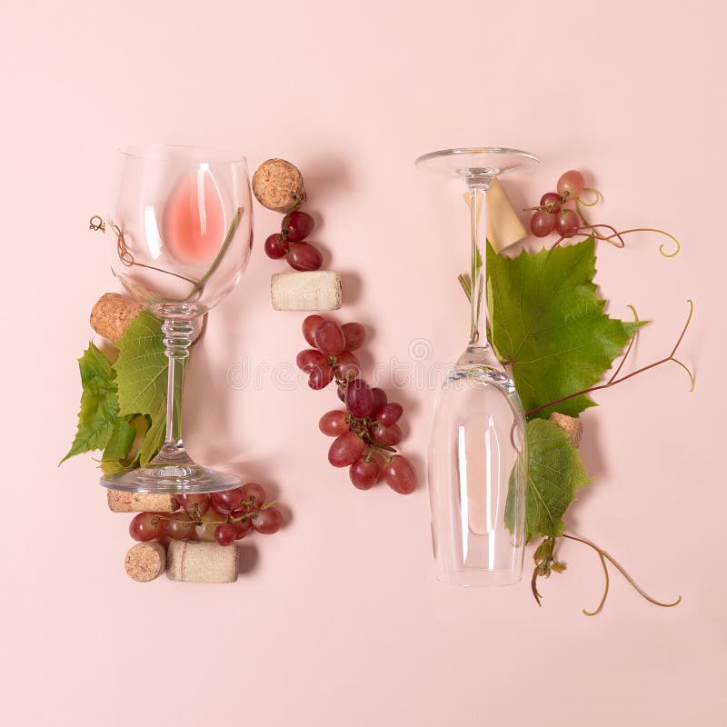 Alphabet Buchstabe N machte von den Weingläsern mit der Rose und Weißwein, Trauben, Blätter und Korken, die auf rosa Hintergrund stockfotos